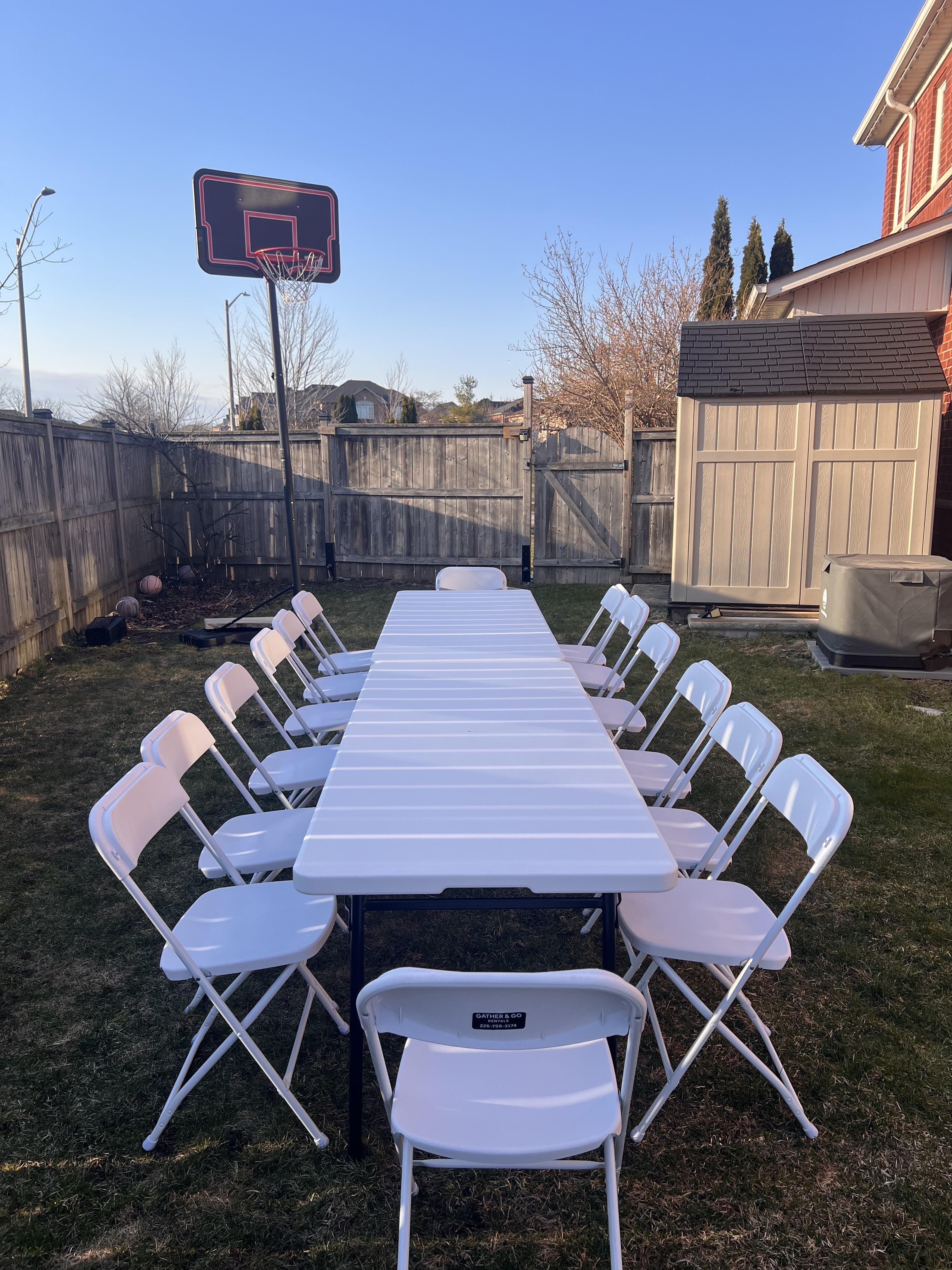 White folding chairs and banquet table setup in backyard - GTA Durham Region rentals